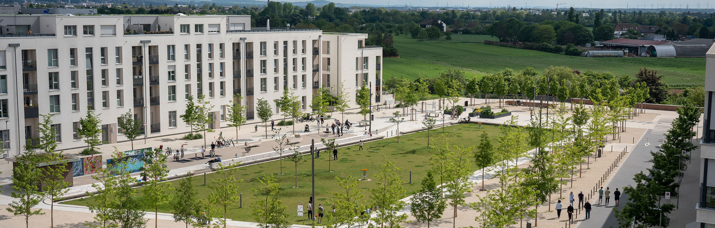 Blick auf Häuser, Wiese und Bäume in der Bahnstadt